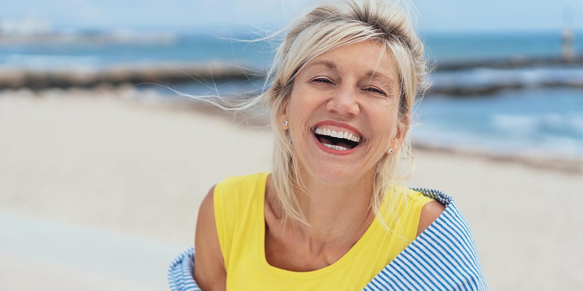 blond lady smiling on the beach