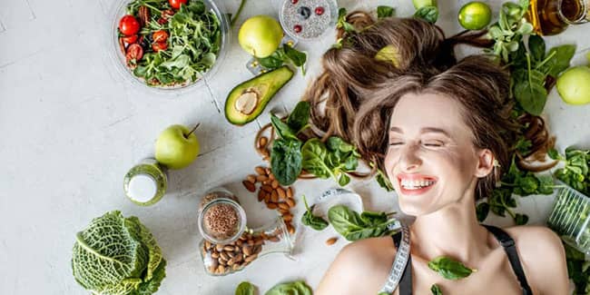 woman surrounded by green vegetables