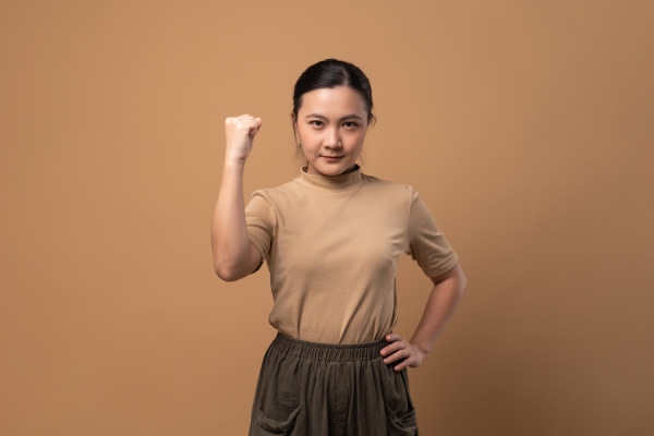 Woman holding up a fist to represent resilience.